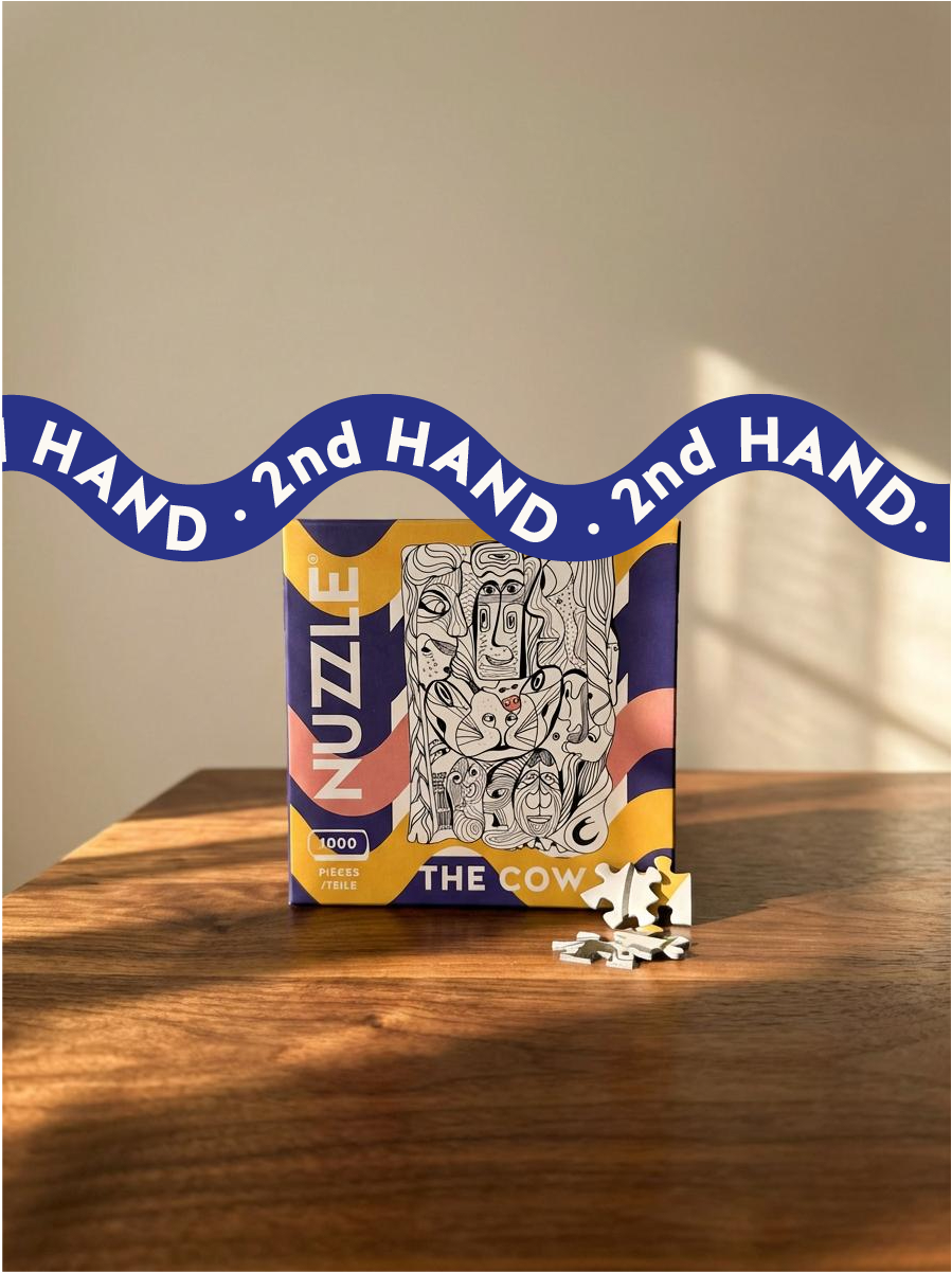 Puzzle box with '2nd Hand' ribbon on a wooden surface